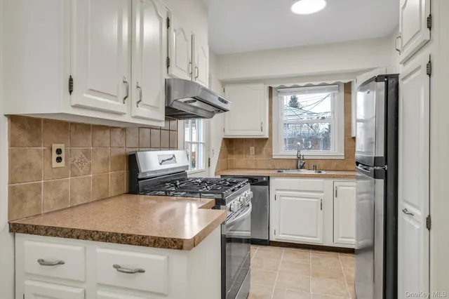 a kitchen with stainless steel appliances granite countertop a sink stove and cabinets