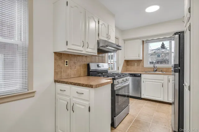 a kitchen with granite countertop white cabinets and white appliances