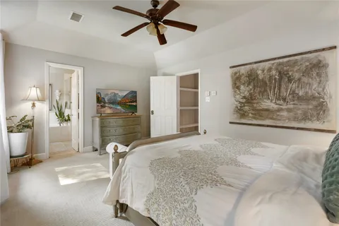 a spacious bedroom with a bed and ceiling fan