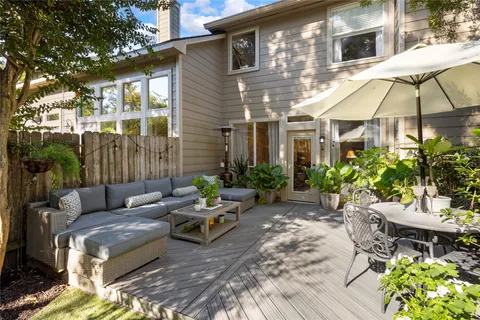 a backyard of a house with table and chairs under an umbrella
