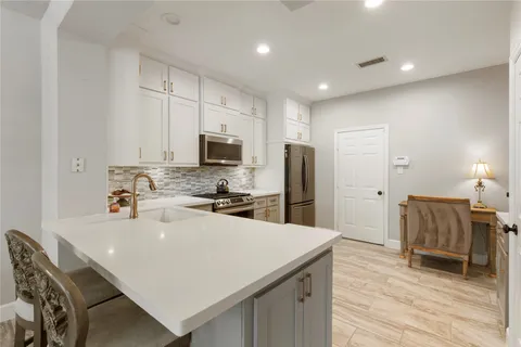 a kitchen with kitchen island a sink appliances and cabinets