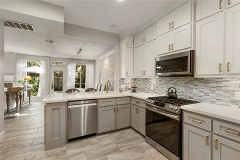a kitchen with stainless steel appliances granite countertop a sink and stove top oven