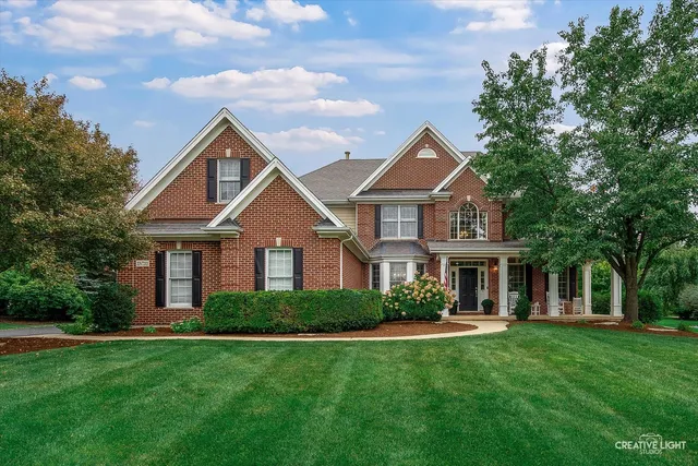 a front view of a house with a yard and trees