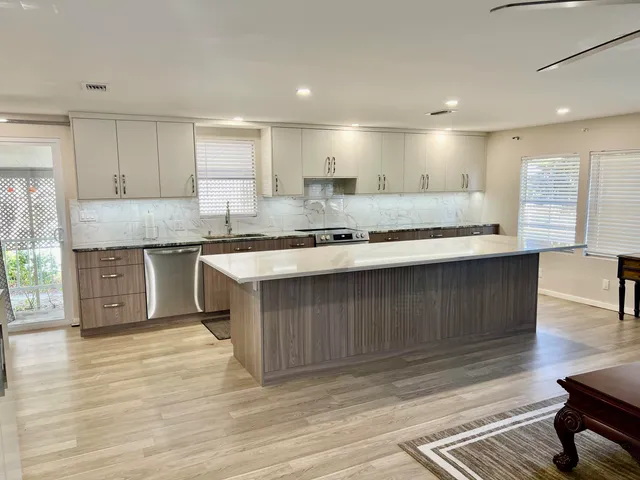 a kitchen with stainless steel appliances granite countertop a stove refrigerator and cabinets