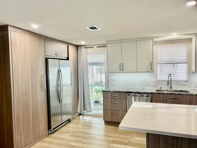 a kitchen with stainless steel appliances granite countertop a refrigerator and a sink