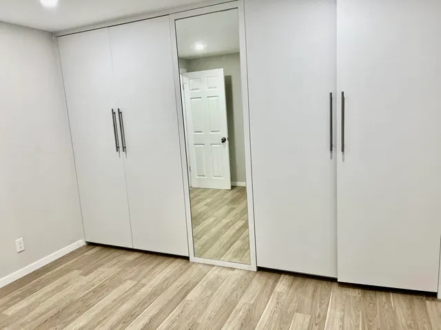 a view of a room with wooden floor and white wall