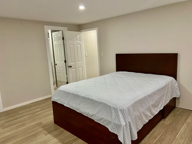 a large bed sitting in a bedroom next to a window