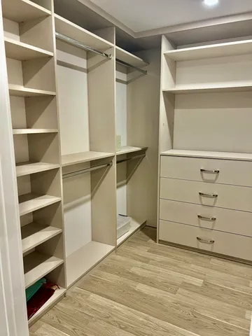 a view of walk in closet with empty racks
