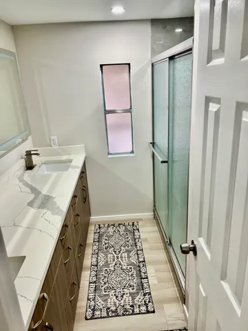 a bathroom with a granite countertop sink and a mirror