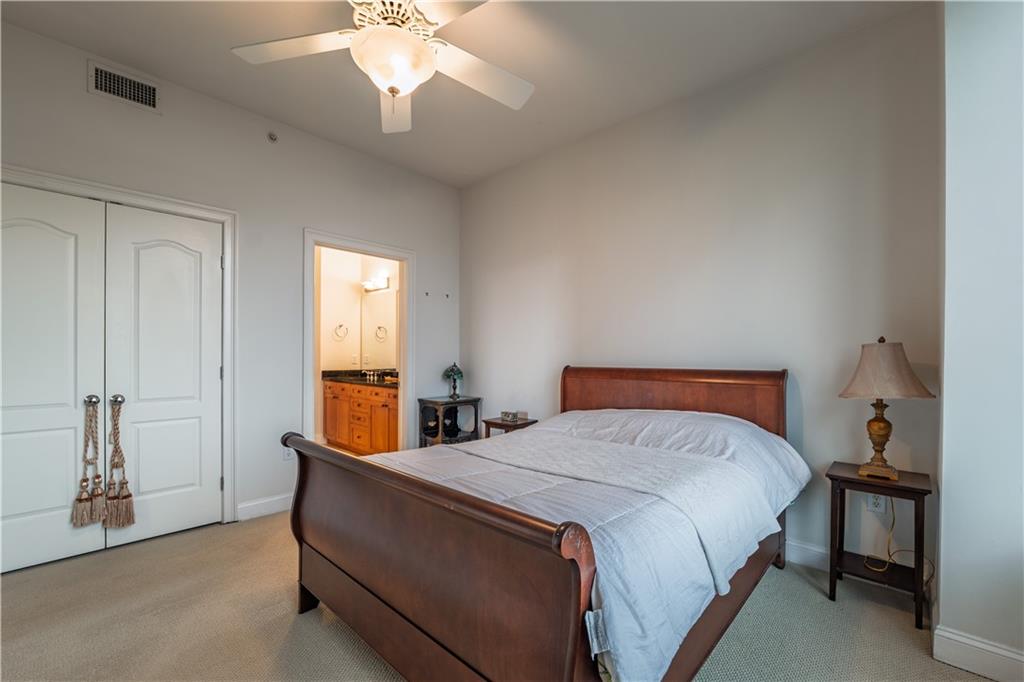 2828 Peachtree Road Northwest, Unit 1501 Atlanta, GA 30305 - Photo 12 of 30 a bedroom with a bed and a chandelier