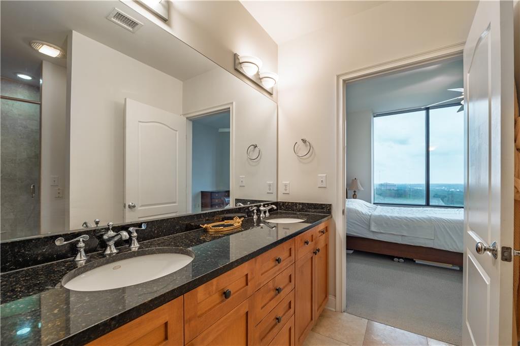 2828 Peachtree Road Northwest, Unit 1501 Atlanta, GA 30305 - Photo 13 of 30 a bathroom with a granite countertop tub sink and mirror