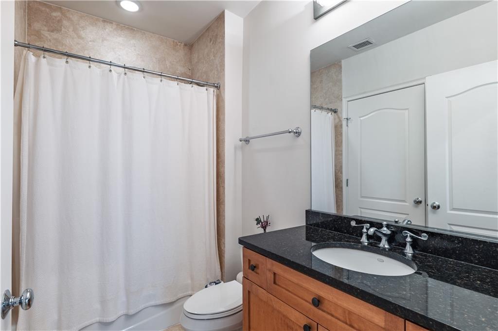 2828 Peachtree Road Northwest, Unit 1501 Atlanta, GA 30305 - Photo 18 of 30 a bathroom with a granite countertop sink toilet and a mirror