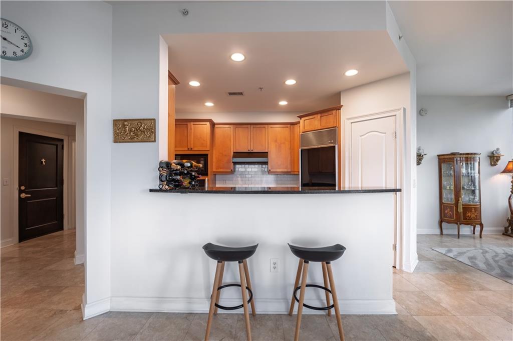 2828 Peachtree Road Northwest, Unit 1501 Atlanta, GA 30305 - Photo 9 of 30 a view of kitchen with stainless steel appliances granite countertop dining table chairs microwave and sink