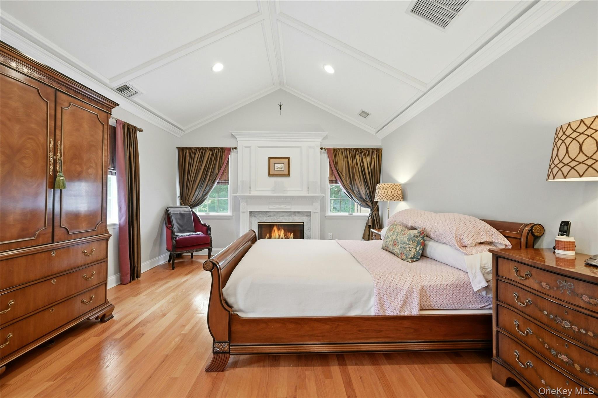 6 Thunder Road Miller Place, NY 11764 - Photo 24 of 50 The Exquisite Primary Bedroom Suite Is An Elegant, Private Oasis Offering Soaring Custom Paneled Ceilings, Fireplace With A Stunning Custom Mantel, Marble Surround & Base, Box Paneled Trim & Beautiful Moldings/Details Flanked By Two Large Windows (There Are Five Large Windows In The Bedroom Illuminating The Room With Natural Light), Hardwood Floors, Ample Room For A Very Large Bedroom Set/Furniture, An Expansive Custom Built Walk In Closet With Built In Shelving/Storage, Second Double Sized Closet, And A Magnificent Primary Bathroom.