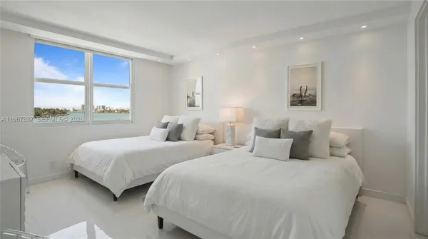 a bedroom with two beds and a large window