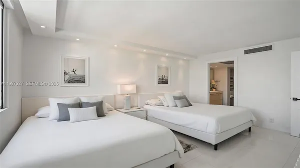 a bedroom with two beds and white walls