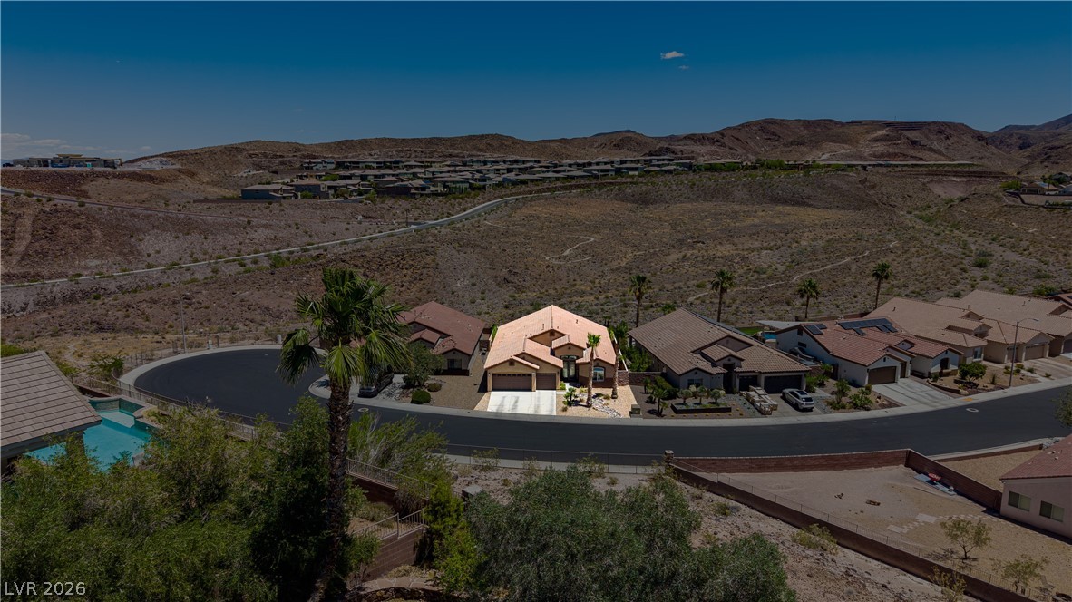 2256 Dogwood Ranch Avenue Henderson, NV 89052 - Photo 7 of 51 An aerial perspective reveals a desert oasis with a single-family residence nestled among surrounding homes and scenic hills.