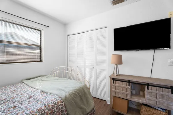 a bedroom with a bed tv and window