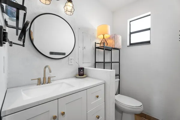 a bathroom with a toilet sink and mirror