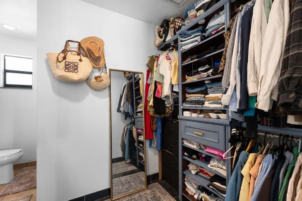 a view of walk in closet with clothes and shoes