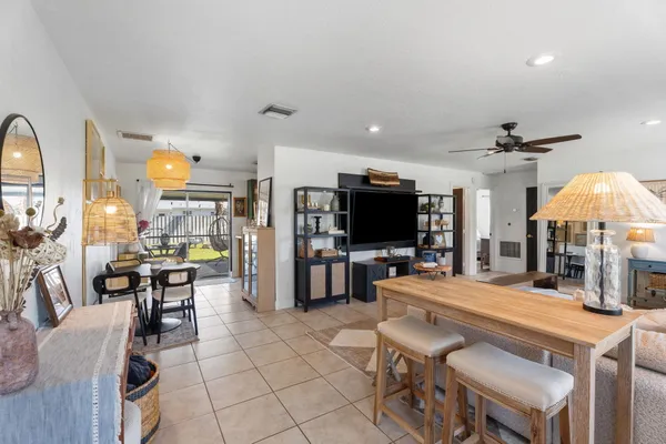 a room with stainless steel appliances lots of white furniture a dining table and chairs