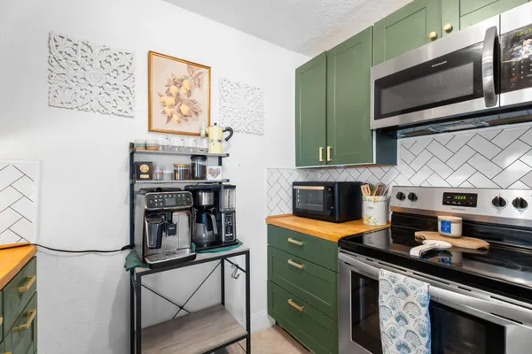 a kitchen with stainless steel appliances a stove a microwave and cabinets