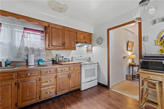 a kitchen with sink cabinets and wooden floor