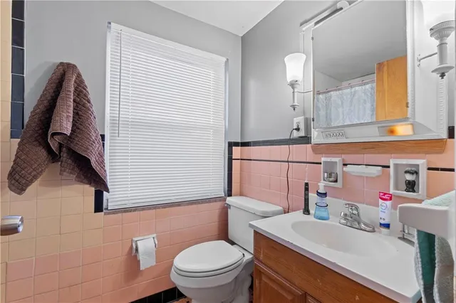 a bathroom with a sink a toilet and a mirror