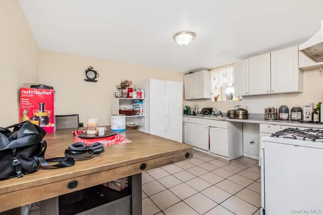 a kitchen with white cabinets and appliances