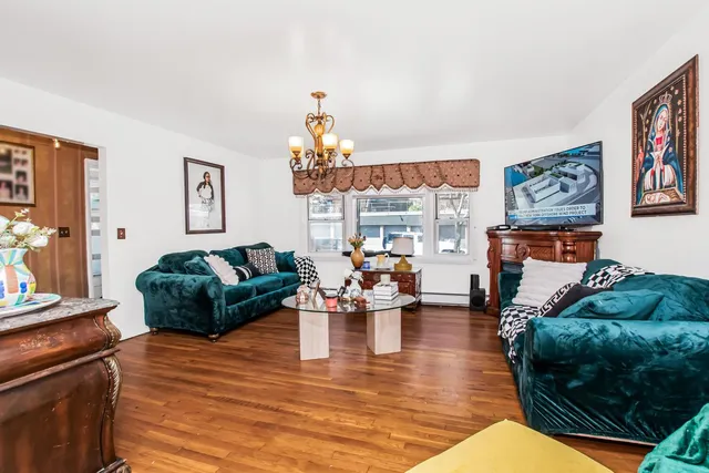 a living room with furniture a fireplace and a chandelier