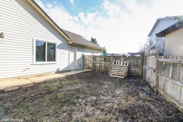 a view of a house with a yard and wooden fence