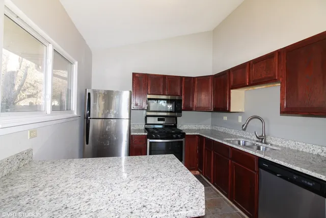 a kitchen with stainless steel appliances granite countertop a refrigerator stove a sink and dishwasher