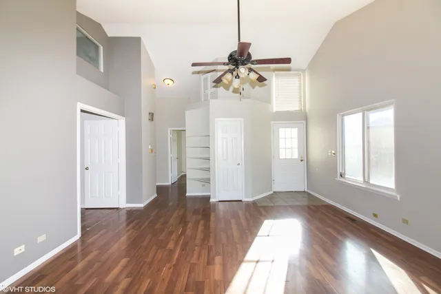 a view of a room with wooden floor and ceiling fan