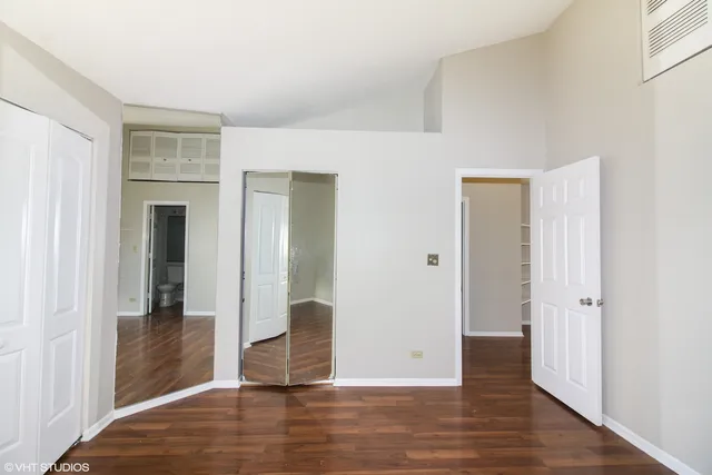 an empty room with wooden floor and entrance