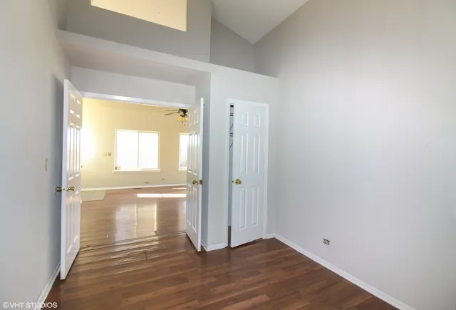 a view of empty room with wooden floor and fan