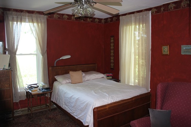 17530 Millard Road Morrison, IL 61270 - Photo 14 of 17 a bedroom with a bed and a chandelier next to a window