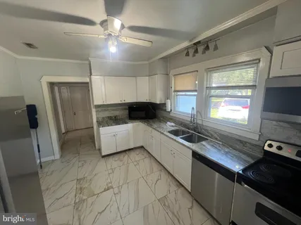 a kitchen with stainless steel appliances a sink cabinets and a window