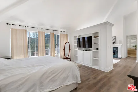 a bedroom with a bed a dresser and a window