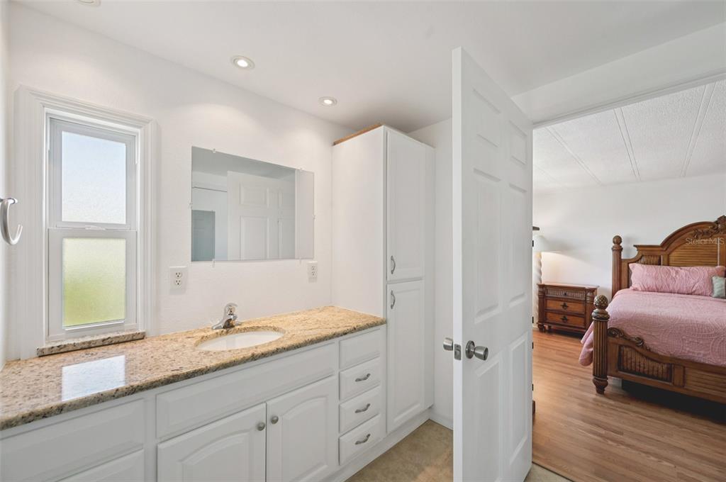 156 Martinique Road North Port, FL 34287 - Photo 19 of 46 a en suite bathroom with a granite countertop sink and a mirror