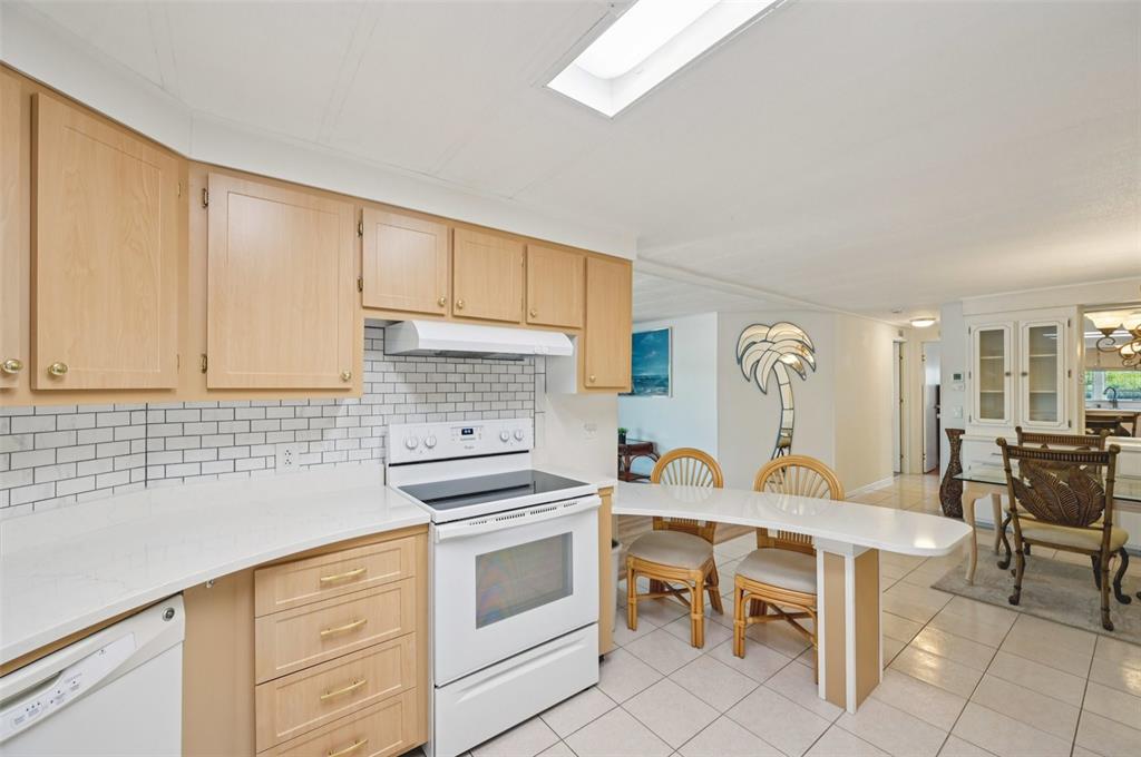 156 Martinique Road North Port, FL 34287 - Photo 6 of 46 a kitchen with a white cabinets and chairs