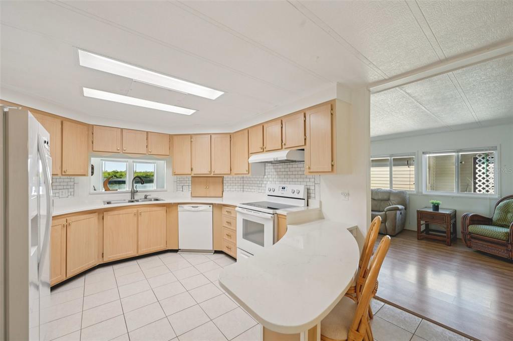 156 Martinique Road North Port, FL 34287 - Photo 7 of 46 a kitchen with a stove a sink dishwasher a dining table and chairs with wooden floor