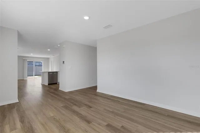 a view of an empty room with wooden floor