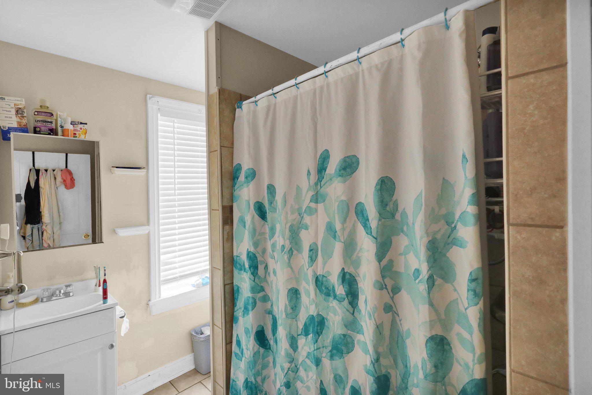 1122 Buttonwood Street Reading, PA 19604 - Photo 13 of 18 a bathroom with a shower curtain and a curtain