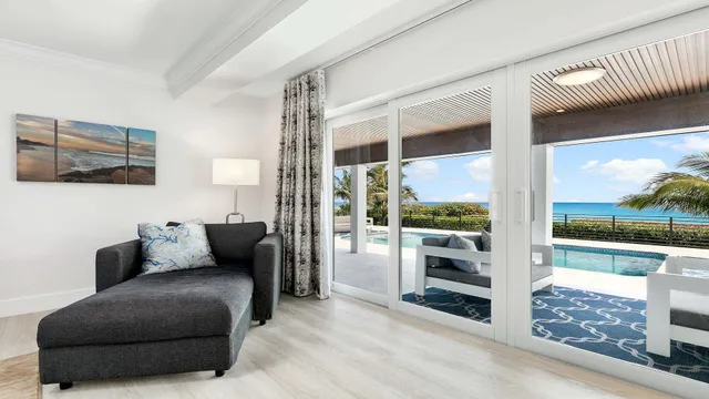 a living room with furniture a floor to ceiling window and outdoor view