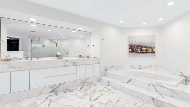 a bathroom with a double vanity sink mirror and bathtub
