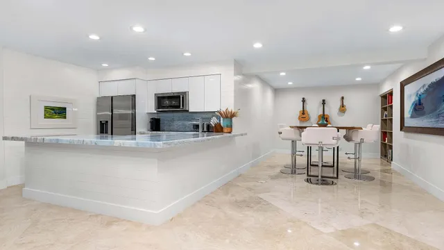 a kitchen with stainless steel appliances kitchen island granite countertop a refrigerator and a stove top oven