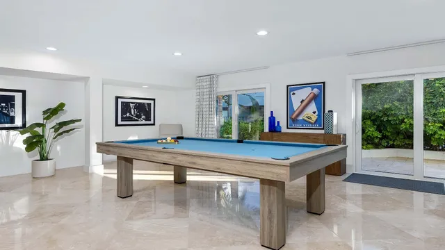 a room with furniture pool table table and windows