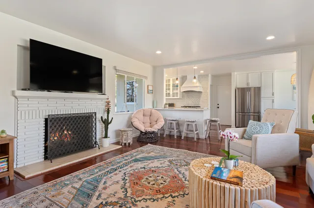 a living room with furniture a flat screen tv and a fireplace