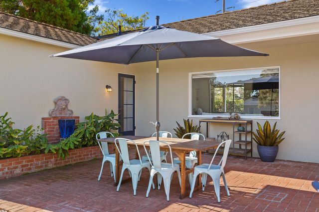 a balcony with table and chairs with wooden fence