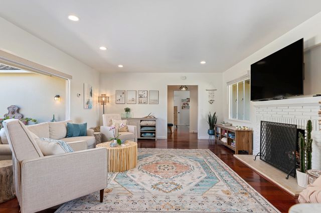 a living room with furniture a fireplace and a flat screen tv